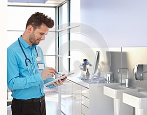 Physician working with tablet in doctors office photo