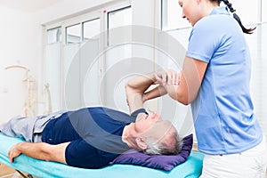 Physio treating senior patient