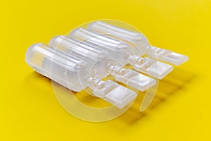 Physiological serum ampoules on a yellow background