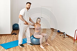 Physioterapist man giving rehab treatment to woman at the clinic