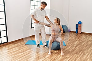 Physioterapist man giving rehab treatment to woman at the clinic