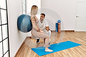 Physioterapist man giving rehab treatment to woman at the clinic