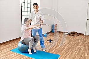 Physioterapist man giving treatment to woman at the clinic