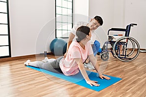 Physioterapist man giving treatment to woman at the clinic