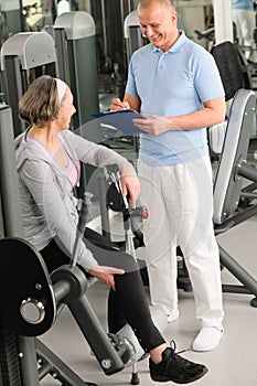 Physiotherapist assist active senior woman at gym