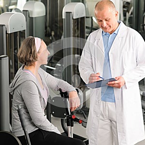 Physiotherapist assist active senior woman at gym