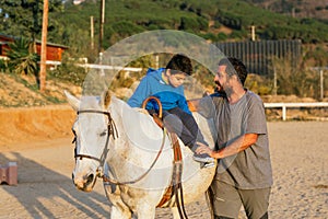 Physiotherapist assisting a child with disabilities in an equine therapy session.