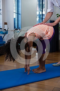 Physiotherapist assisting girl in exercising