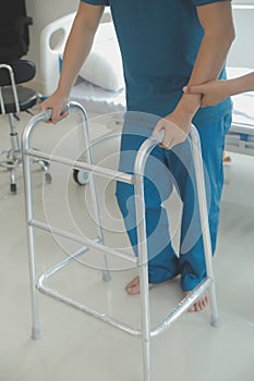 Physiotherapist assists her contented senior patient on folding walker. Recuperation for elderly, seniors care, nursing home