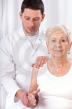 Physiotherapist checking arm motor abilities photo