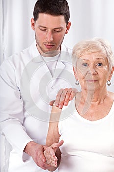 Physiotherapist checking arm motor abilities