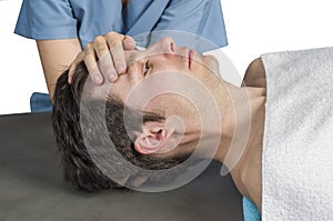 Physiotherapist, chiropractor doing a cranial sacral therapy to