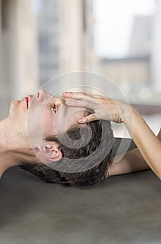 Physiotherapist, chiropractor doing a cranial sacral therapy to