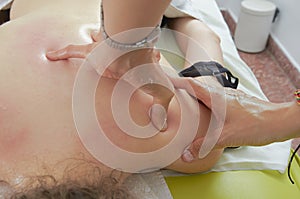 Physiotherapist, chiropractor giving a back massage to a patient