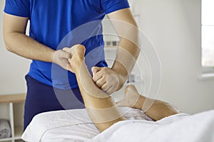 Physiotherapist, chiropractor, masseur, or osteopath massaging his patient& x27;s leg