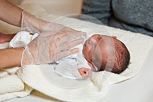 Physiotherapist conducting an assessment of diaphragmatic and rib expansion on a newborn baby.