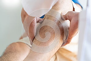 Physiotherapist doctor rehabilitation consulting physiotherapy giving exercising leg treatment with patient in physio clinic or ho