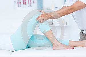 Physiotherapist doing leg massage to his patient photo