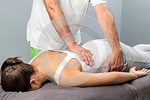 Physiotherapist doing massage on female lower back.