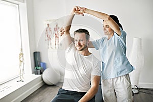 Physiotherapist doing treatment with patient in bright office