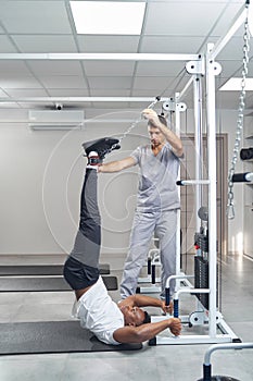 Physiotherapist employing gym equipment for patient spinal traction