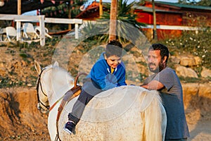Physiotherapist during an equine therapy session with a disabled child
