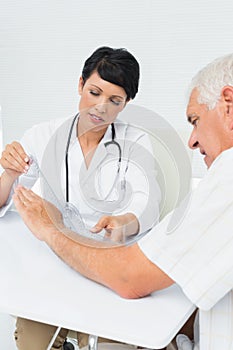 Physiotherapist examining patients wrist with goniometer