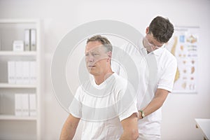 Physiotherapist examining senior man man