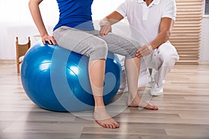 Physiotherapist Examining Woman`s Injured Leg