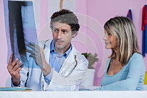 Physiotherapist explaining x-ray to patient
