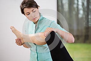 Physiotherapist flexing knee