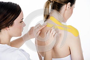 Physiotherapist getting taping on the trapezius woman