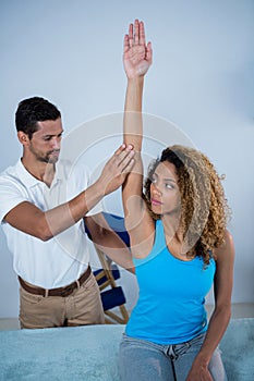 Physiotherapist giving arm massage to female patient