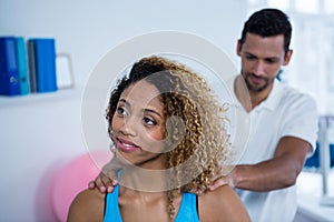 Physiotherapist giving back massage to female patient