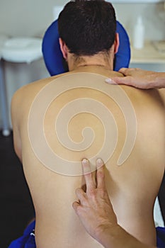 Physiotherapist giving back massage to a patient