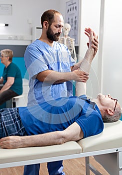 Physiotherapist giving chiropractic massage to elder man