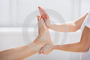 Physiotherapist Giving Exercise On Man`s Foot