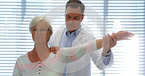 Physiotherapist giving hand massage to senior woman