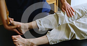 Physiotherapist giving leg therapy to senior woman 4k