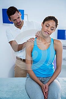 Physiotherapist giving neck massage to female patient