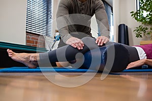 Physiotherapist giving physical therapy of leg to patient photo