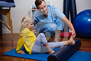 Physiotherapist giving physical therapy to the girl