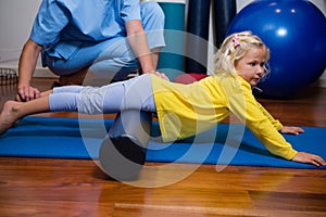 Physiotherapist giving physical therapy to the girl