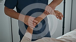 Physiotherapist hands massaging patient arm on rehab closeup. Man doctor healing