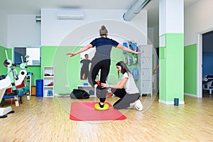 A physiotherapist has a patient perform exercises for ankle proprioception