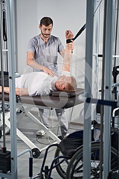 Physiotherapist help man on decompression simulator in rehab room