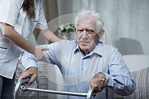 Physiotherapist helping disabled senior man