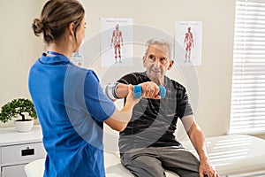Physiotherapist helping senior man exercise