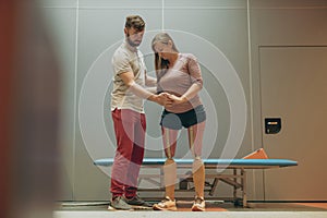 Physiotherapist helping young woman with prosthetic legs