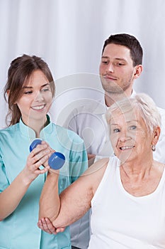 Physiotherapist insuring senior during exercise